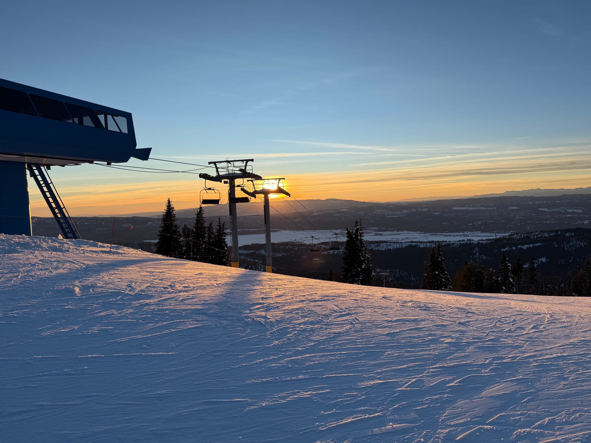 Picture of sun setting behind a ski lift.